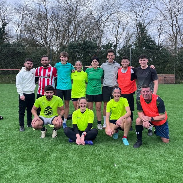 Equipo mixto de adultos posando tras un partido en el campo