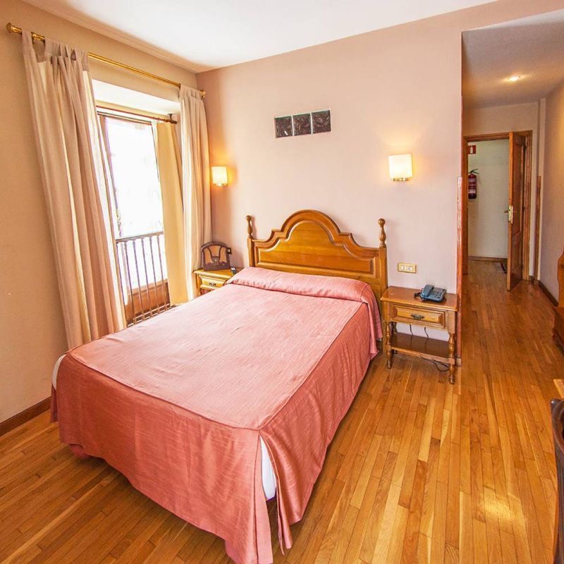 Habitación doble del hotel con cama de matrimonio y balcón