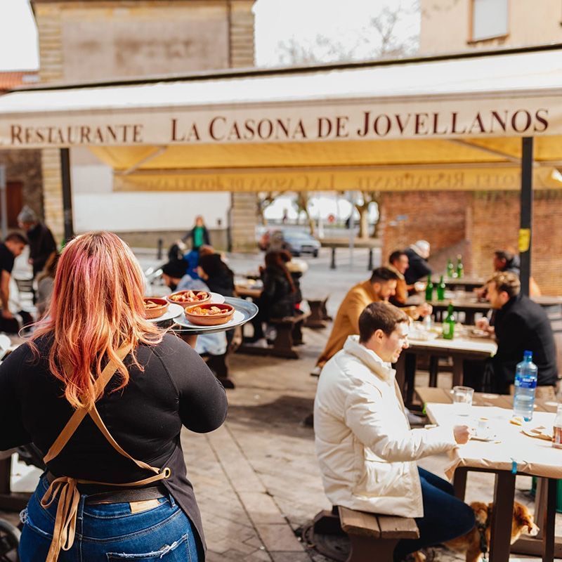Terraza del restaurante sidrería La Casona de Jovellanos con clientes comiendo